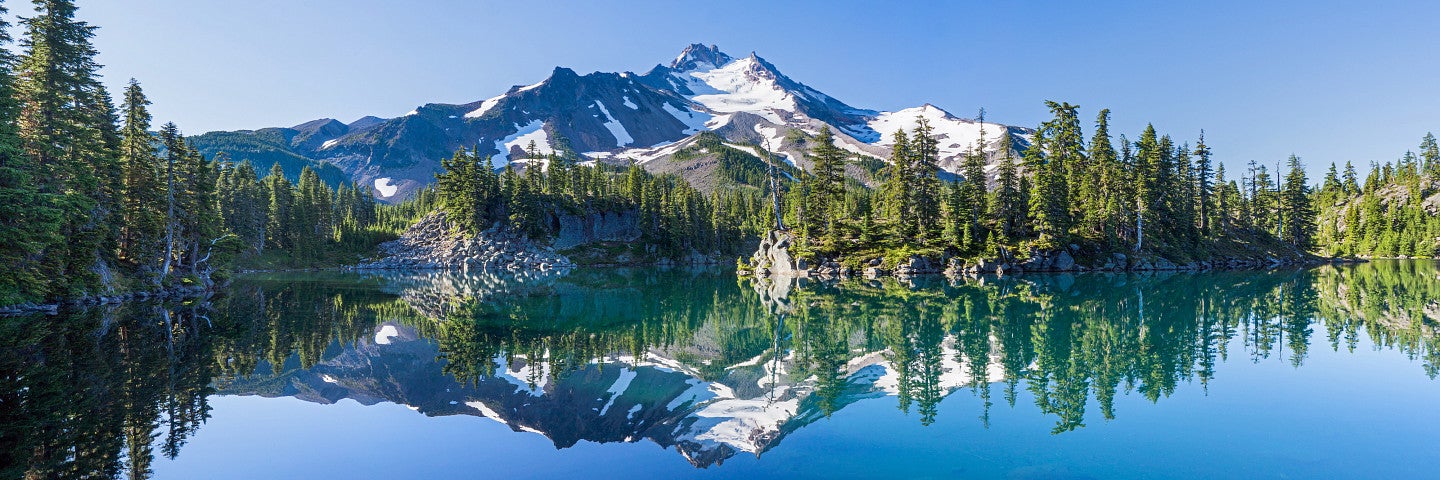 View of mountains and trees reflecting in a blue lake