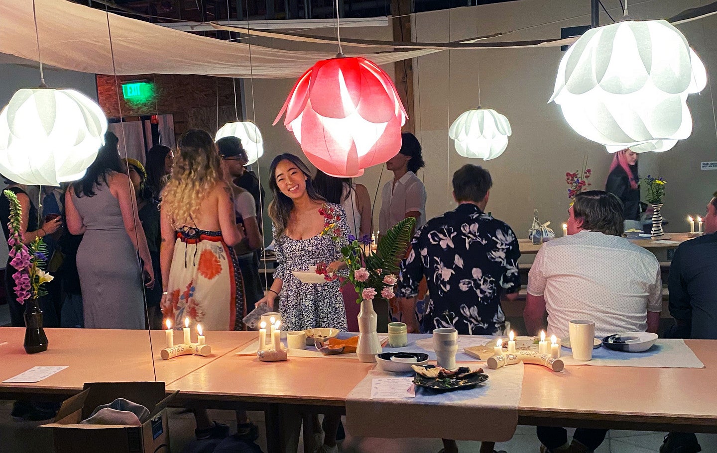 Kiera and classmates at a formal party surrounded by colorful, unique lighting fixtures